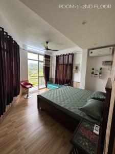 达兰萨拉Dhauladhar Homes的一间卧室设有一张床和一个大窗户