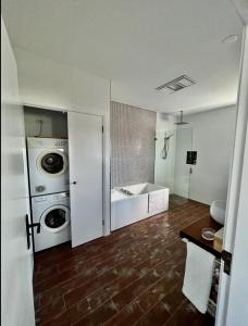 LowtherThe View @ Ulandi的浴室配有洗衣机、洗衣机和烘干机。