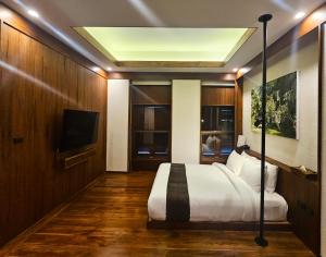 讪巴东高迈兰纳度假村的一间卧室配有一张床和一台平面电视