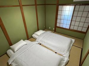 泉佐野KIX House Waraku III 和楽三号館的小房间设有两张床和两个窗户