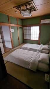 泉佐野KIX House Waraku III 和楽三号館的一张大床,位于带绿色墙壁的房间