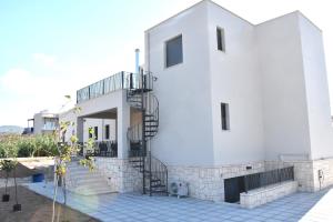 爱琴娜岛Polles Εlies Cozy Αpartment的白色的房子,上面有螺旋楼梯