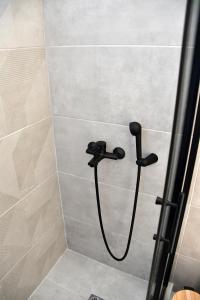 爱琴娜岛Polles Εlies Cozy Αpartment的浴室内配有带黑色淋浴喷头的淋浴