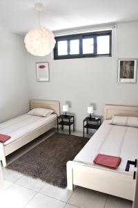 爱琴娜岛Polles Εlies Cozy Αpartment的配有两张桌子和吊灯的客房内的两张床