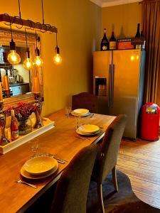 基尔Deluxe Altbaucharme in zentraler Lage的厨房配有一张带椅子的木桌和一台冰箱