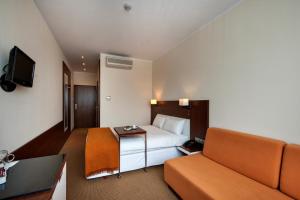 皮佐维斯德斯瓦客栈卡托维兹机场的酒店客房,配有床和沙发