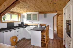 加尔盖伦Alpenhaus Montafon的厨房配有白色橱柜和木制天花板