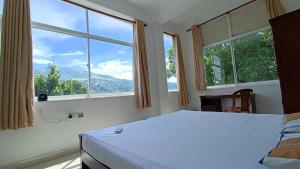 康提Smile Hub Kandy的一间卧室设有一张床和两个大窗户