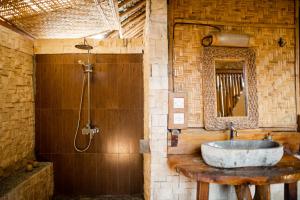森纳儒林家尼灯塔宾馆的一间带石质水槽和淋浴的浴室