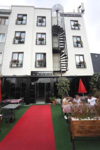 伊斯坦布尔Yuvam akmarmara hotel的一座白色的大建筑,有红地毯和一座建筑