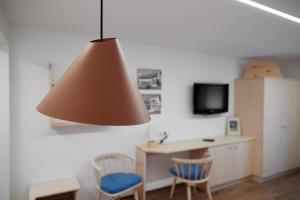 加尔盖伦Alpenhaus Montafon的一间设有桌子、两把椅子和一盏灯的房间