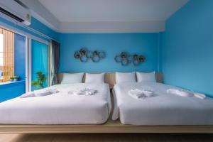 甲米镇Otter House Aonang Intersection的蓝色墙壁客房的两张床