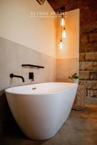 克拉伦斯Andes Clarens Guesthouse的砖墙浴室内的白色浴缸