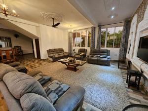 拉穆Ras Kitao Holiday Villa的客厅配有沙发和桌子