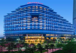 珠海珠海华发喜来登酒店的一座蓝色的大建筑,前面有灯