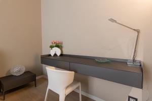 阿格里真托Deluxe apartment Milia Agrigento的一张桌子,在一间有白色椅子的房间