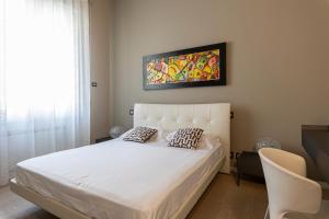 阿格里真托Deluxe apartment Milia Agrigento的卧室配有白色的床和墙上的绘画作品