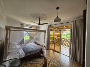 拉穆Ras Kitao Holiday Villa的一间卧室配有一张带天蓬的床
