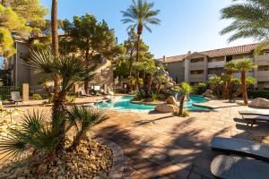 拉斯维加斯Stylish, Cozy 2BR,2BA Condo near Rio, Vegas Luxury的庭院设有棕榈树游泳池
