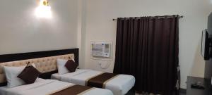 KushinagarJ P PALACE的酒店客房设有两张床和窗户。