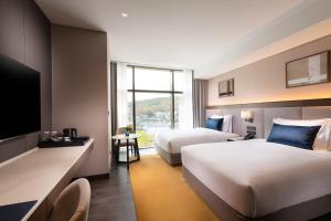 城南市DoubleTree By Hilton Seoul Pangyo Residences的酒店客房设有两张床和电视。