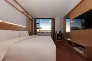 大理大理古城亚朵酒店的卧室设有白色的床和大窗户