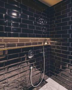 上海The Drama的浴室设有黑色砖墙和淋浴。