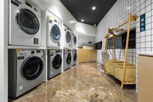 重庆重庆李子坝两路口地铁站亚朵酒店的洗衣房配有4台洗衣机和烘干机