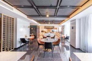 乌鲁木齐乌鲁木齐机场德港万达亚朵酒店的一间在房间内配有桌椅的餐厅