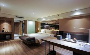 哈尔滨哈尔滨哈西高铁站亚朵酒店的酒店客房配有一张床、一张书桌