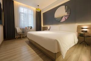 北京北京建国门CBD亚朵轻居酒店的卧室配有一张白色大床和镜子