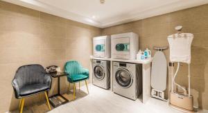无锡无锡三阳广场亚朵酒店的洗衣房配有洗衣机和椅子