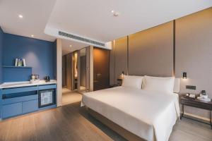 上海上海徐家汇天钥桥亚朵S酒店的卧室配有一张白色大床和蓝色的墙壁