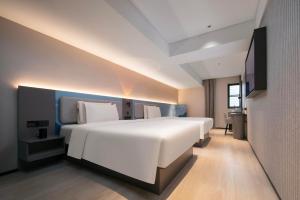 武汉武汉江滩江汉路步行街轻居酒店的卧室配有一张白色大床