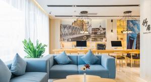 上海上海虹桥国展吴中路亚朵酒店的客厅配有蓝色的沙发和桌子