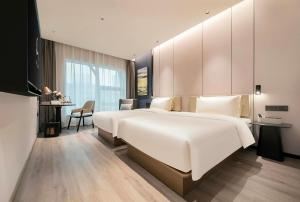 上海上海陆家嘴浦东大道亚朵酒店的卧室配有一张白色大床和一张书桌