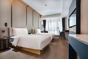 昆明昆明长水国际机场亚朵酒店的酒店客房配有两张床和一张书桌