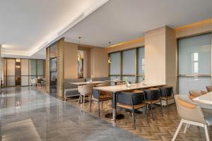 西宁西宁海湖新区国投广场亚朵S酒店的餐厅设有桌椅和窗户。