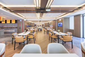 北京Atour Hotel Beijing Capital Airport New International Exhibition Center的一间带桌椅的餐厅和一间酒吧