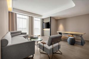 西宁西宁海湖新区国投广场亚朵S酒店的客厅配有沙发、椅子和桌子