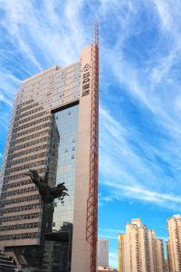 深圳深圳南山海岸城亚朵酒店的一座高大的建筑,前面有鸟雕像