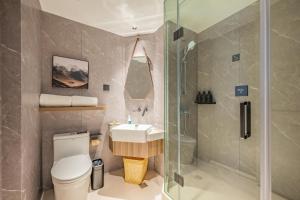 上海上海中环百联铜川路地铁站亚朵X酒店的浴室配有卫生间、盥洗盆和淋浴。