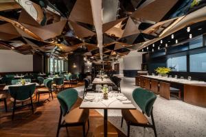 上海上海徐家汇A.T.HOUSE酒店的一间带桌椅和三角形天花板的餐厅
