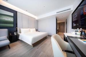 青岛青岛崂山区石老人海水浴场亚朵酒店的酒店客房配有白色的床和沙发。