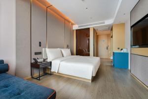 昆明昆明长水国际机场亚朵酒店的卧室配有一张白色大床和电视。