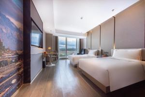 昆明昆明市政府春融街亚朵酒店的酒店客房设有两张床和一台平面电视。