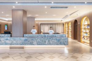 青岛青岛崂山区石老人海水浴场亚朵酒店的两人站在酒店大堂的柜台