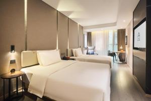 重庆重庆天地网易云音乐亚朵酒店的酒店客房设有两张床和电视。