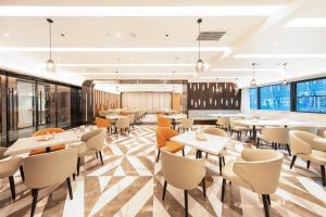 南昌南昌西站国际博览城亚朵酒店的餐厅设有桌椅和窗户。