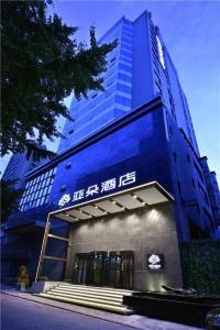 大连大连中山广场亚朵酒店的一座蓝色的大建筑,前面设有楼梯